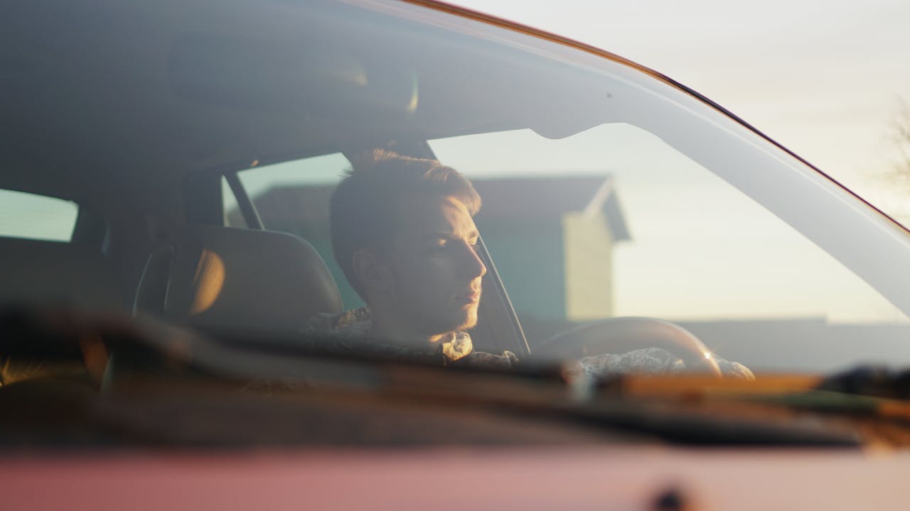 A young man on the driver side of a car